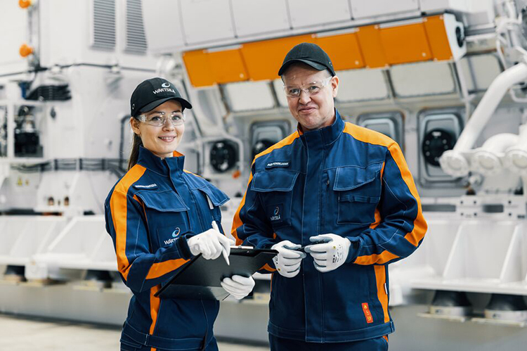 Wärtsilä employees in front of an engine